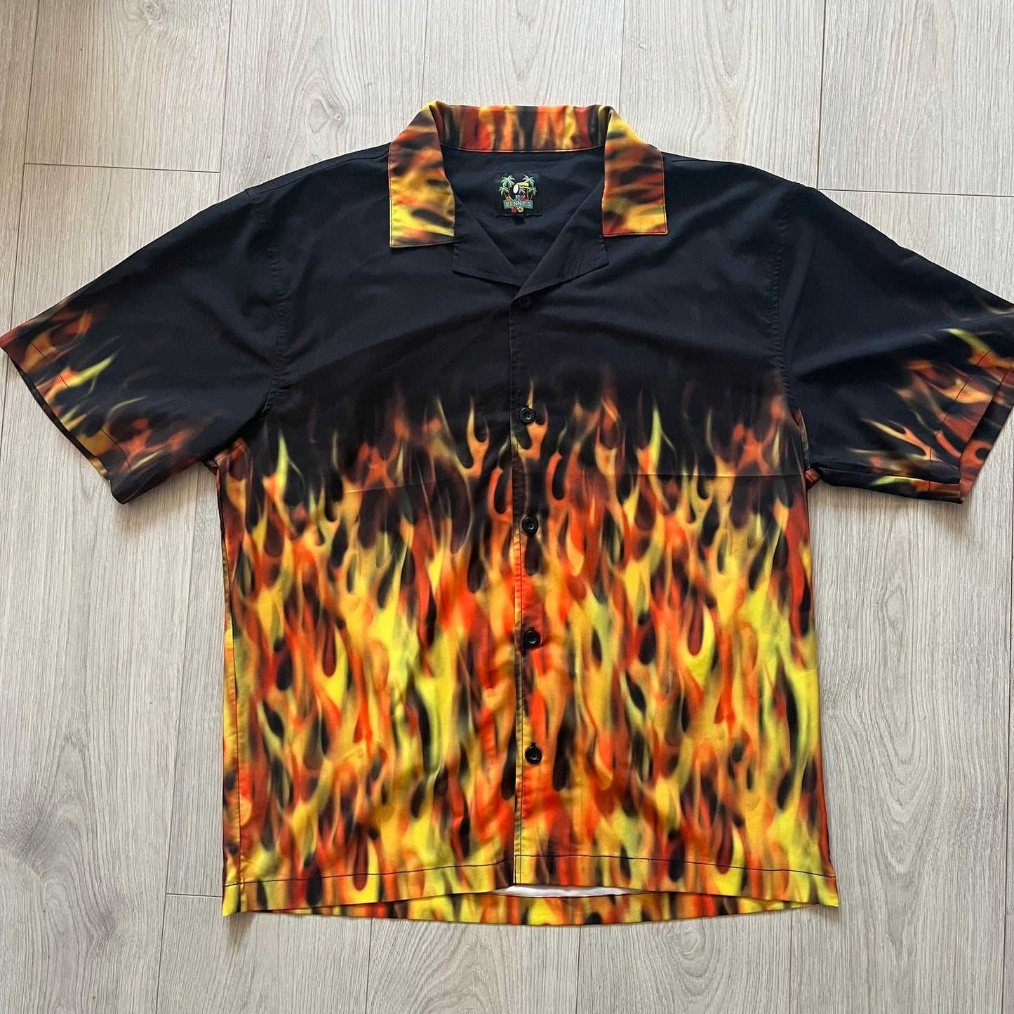 Black shirt with flame pattern on a wooden floor