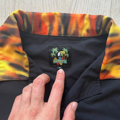 Close-up of a colorful shirt collar with a brand label, held by a hand.