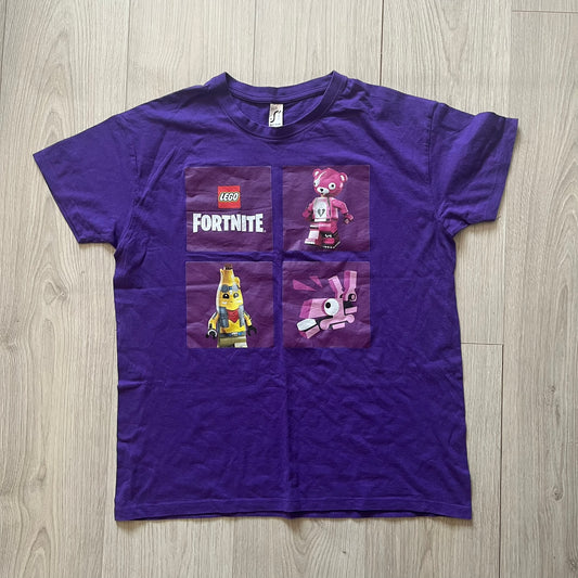 Purple t-shirt with LEGO Fortnite characters on a wooden surface