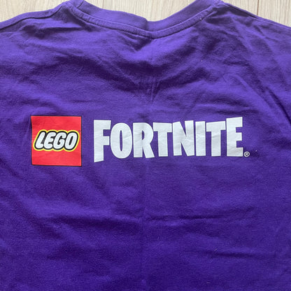 Purple t-shirt with LEGO Fortnite logo on a wooden surface