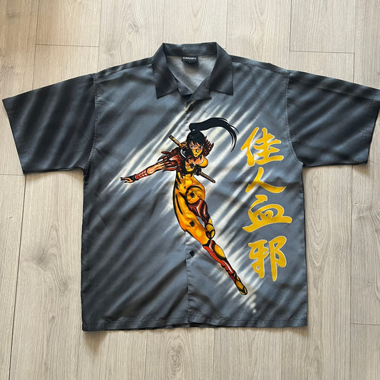 Gray shirt with a colorful graphic of a warrior and Chinese characters on a wooden floor.