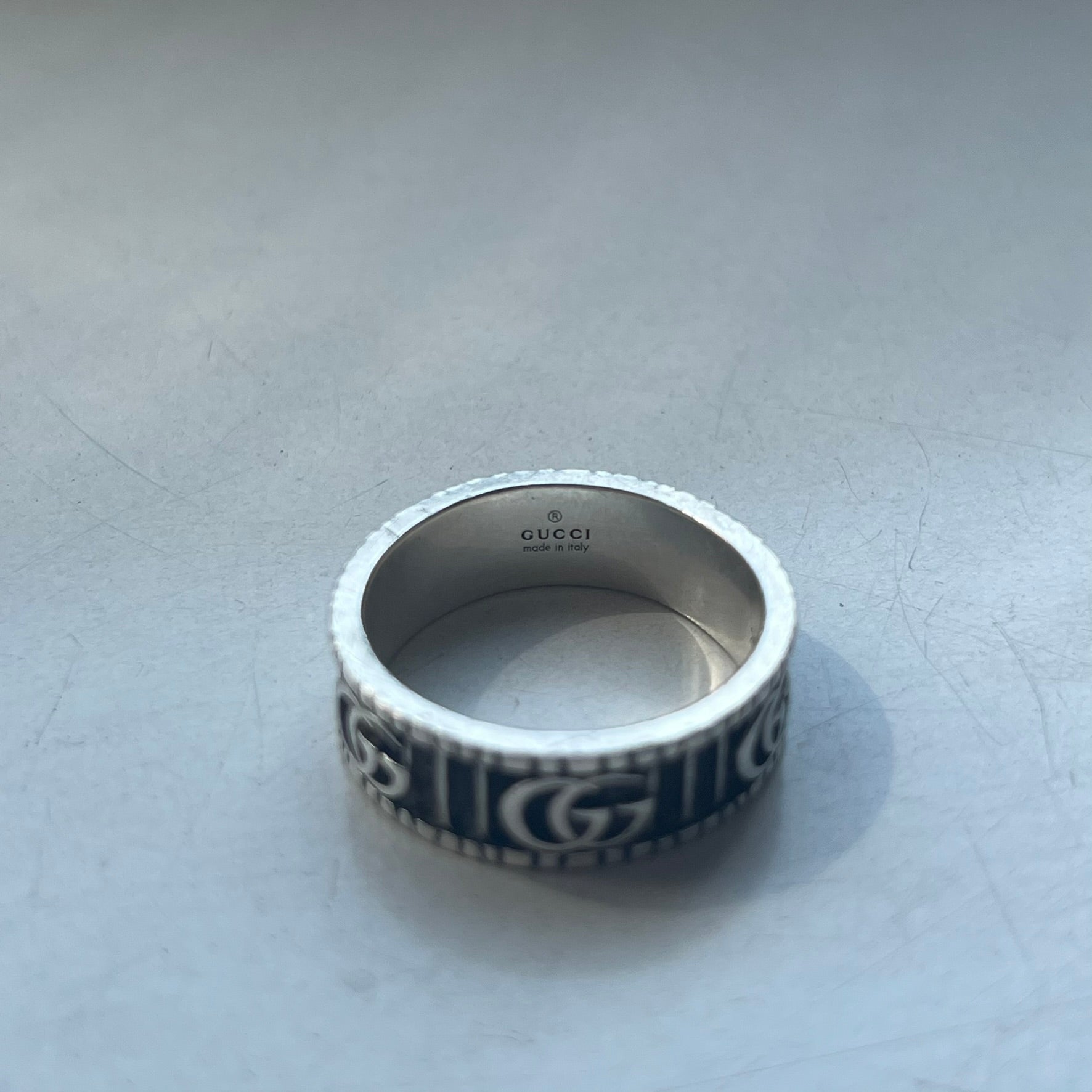 Silver Gucci ring on a light gray surface