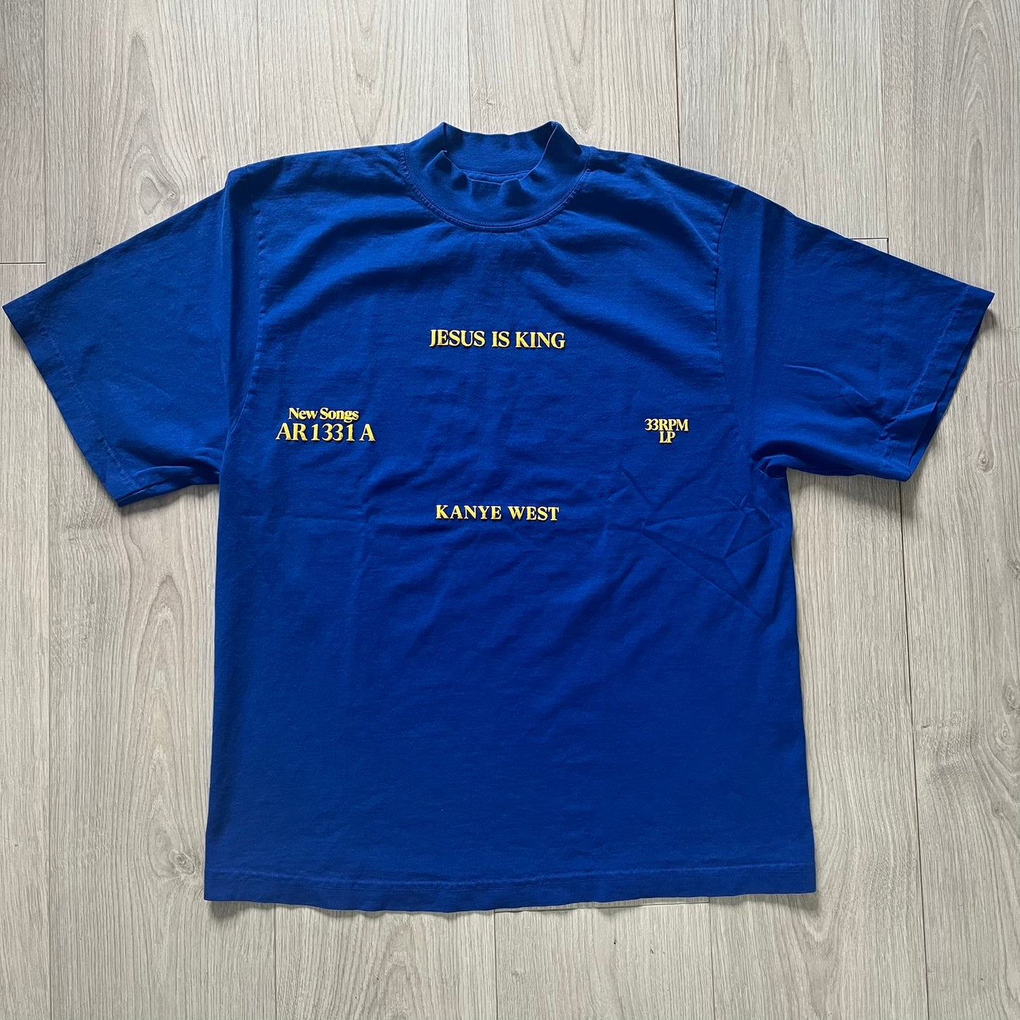 Blue t-shirt with text on a wooden surface
