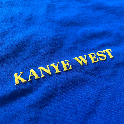 Blue fabric with 'Kanye West' embroidered in yellow