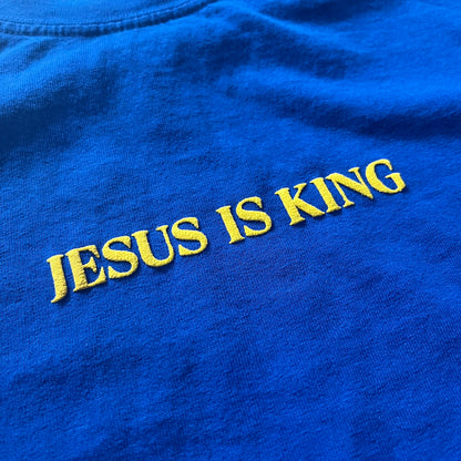 Blue shirt with 'Jesus is King' embroidered in yellow text