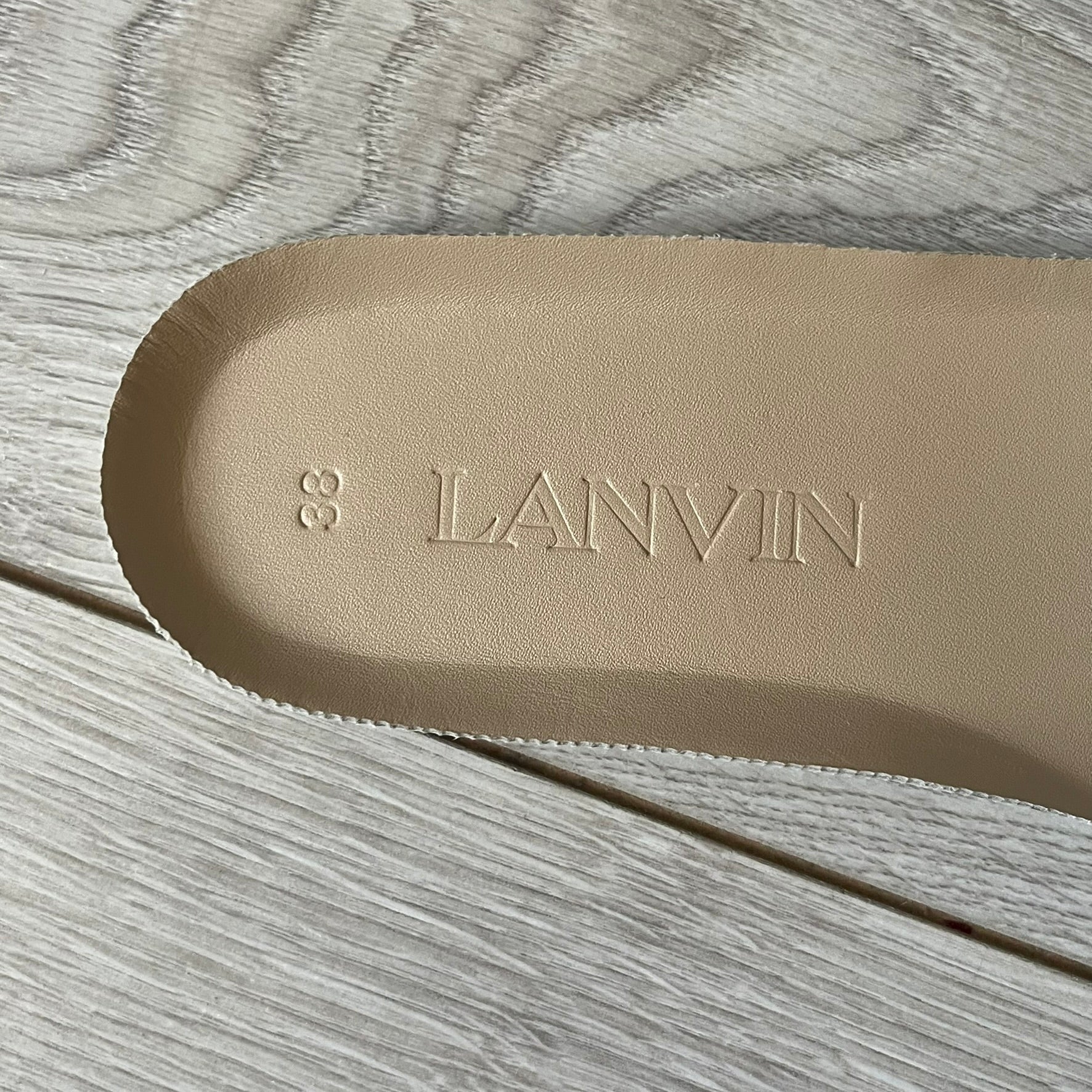 Beige insole with 'LANVIN' branding on a wooden surface