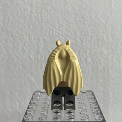 Gold-colored insect figure on a clear baseplate against a gray background