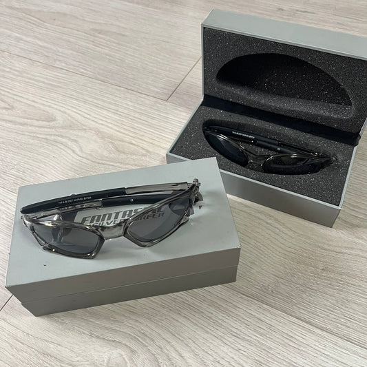 Black sunglasses on a gray box with Fantastic 4 branding on a wooden surface