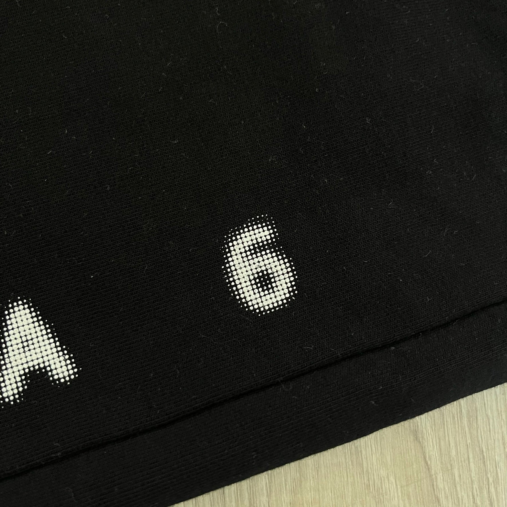 Black fabric with white text and number on a wooden surface