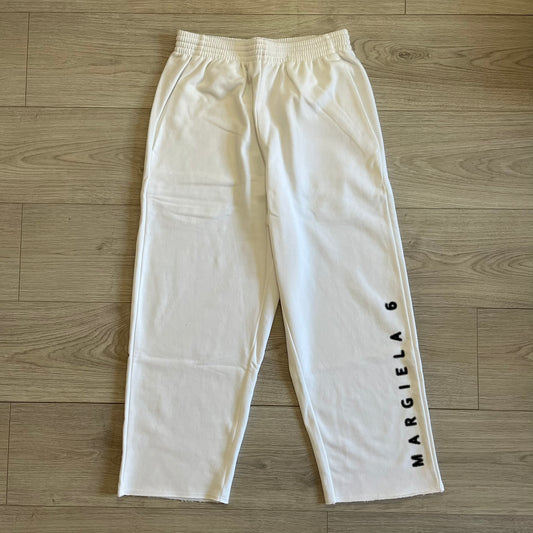 White pants with 'MARGIELA 6' text on a wooden floor