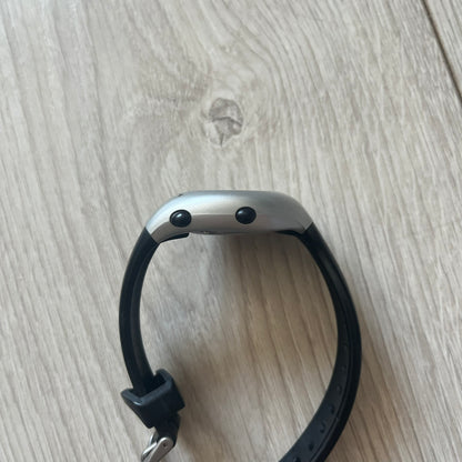 Black smartwatch on a light wooden surface