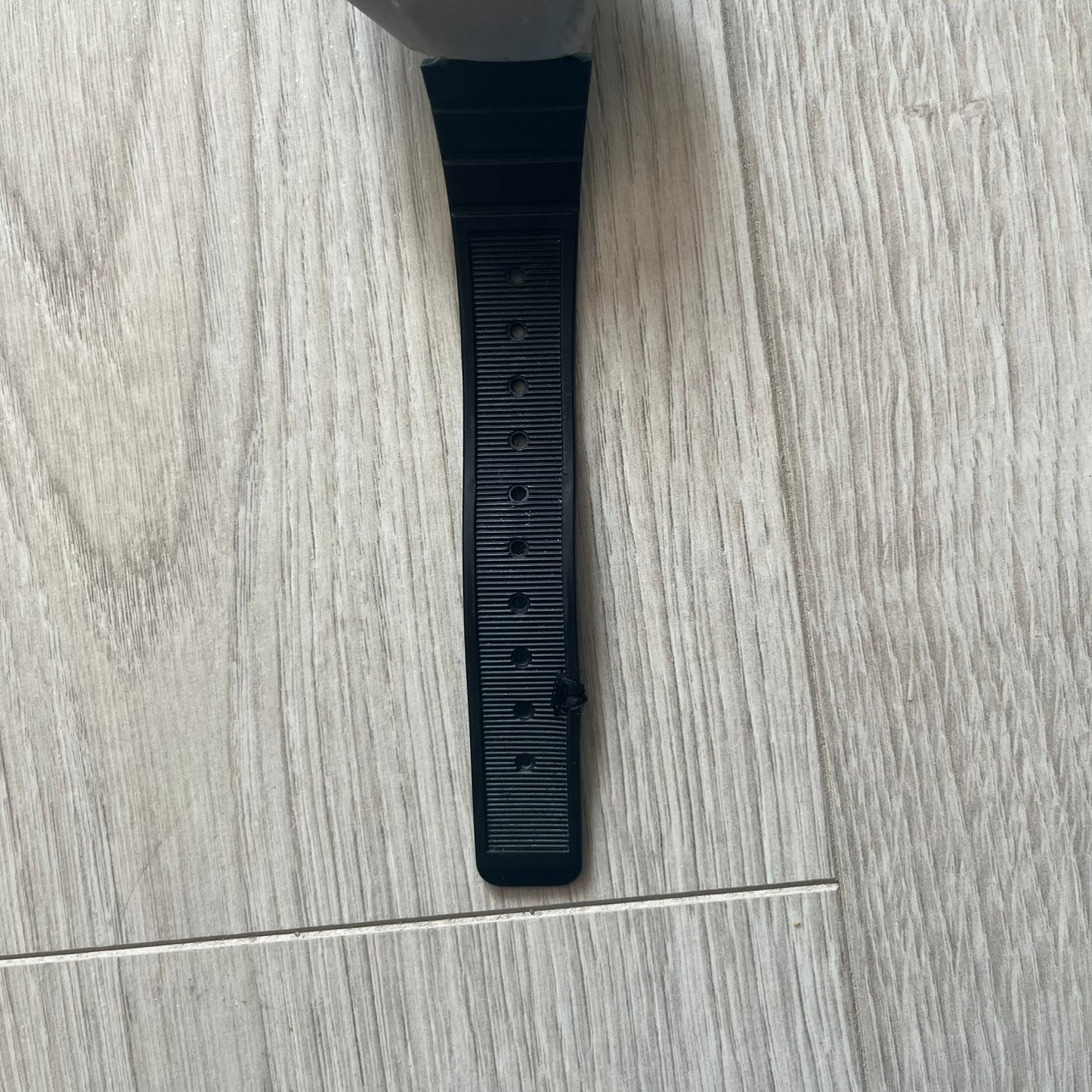 Black strap on a wooden floor