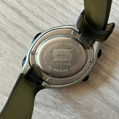 Close-up of a watch case with branding on a wooden surface