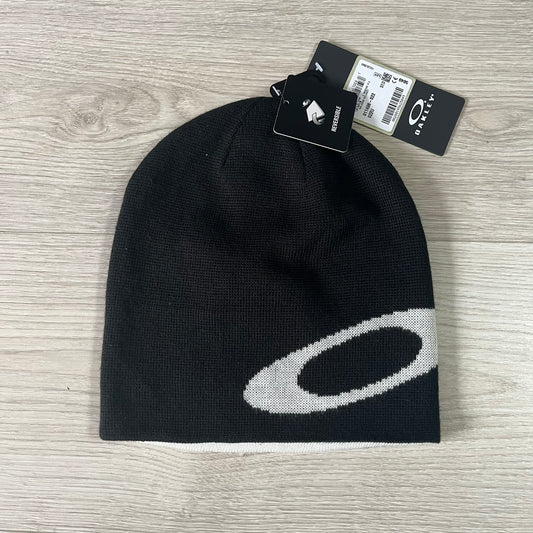 Black beanie with a white logo on a wooden surface