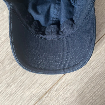 Navy blue cap on a light wooden surface