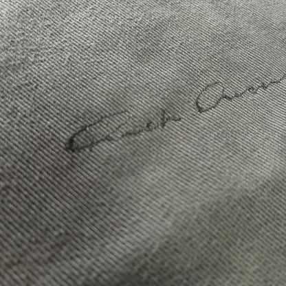 Signature on a textured gray fabric surface