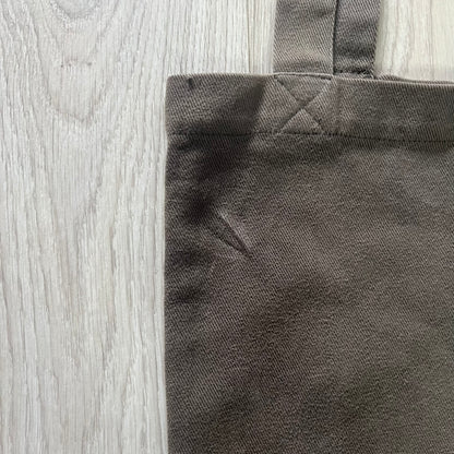 Close-up of a dark gray fabric corner on a wooden surface