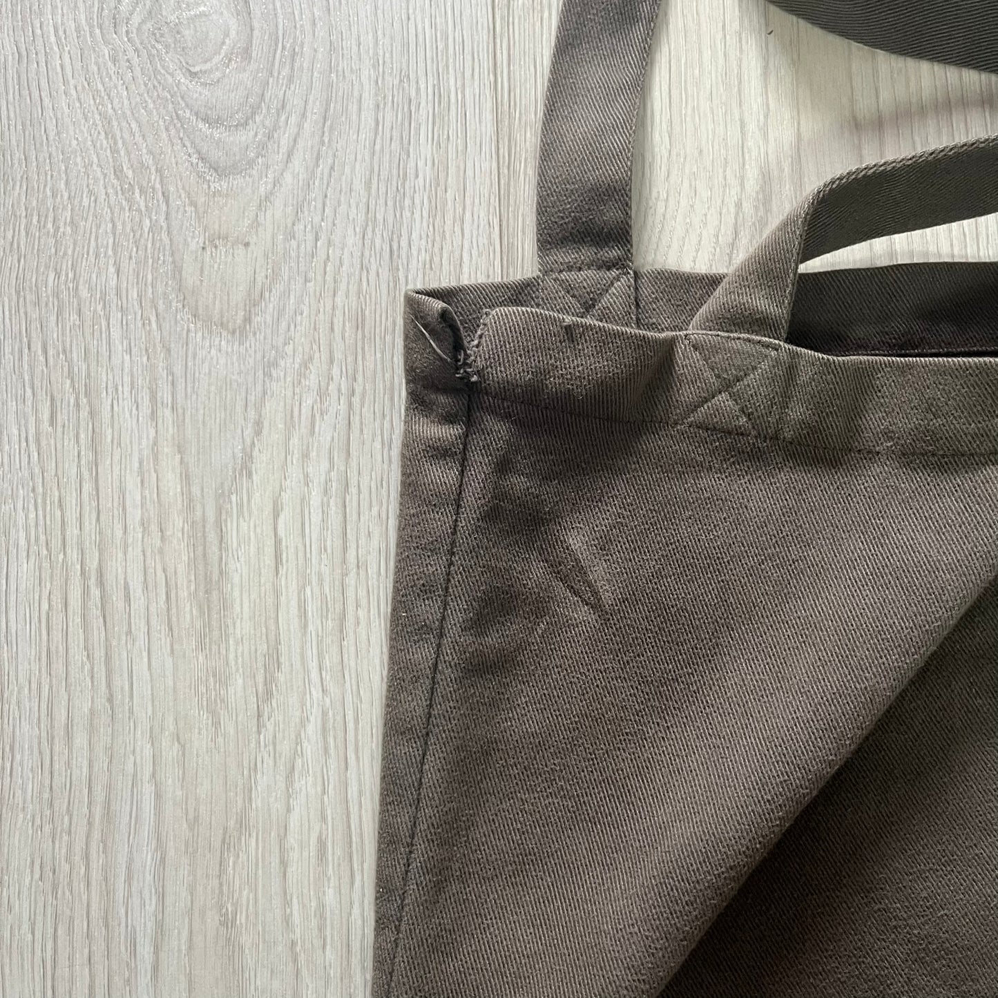 Gray tote bag with handles on a wooden surface