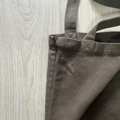 Gray tote bag with handles on a wooden surface