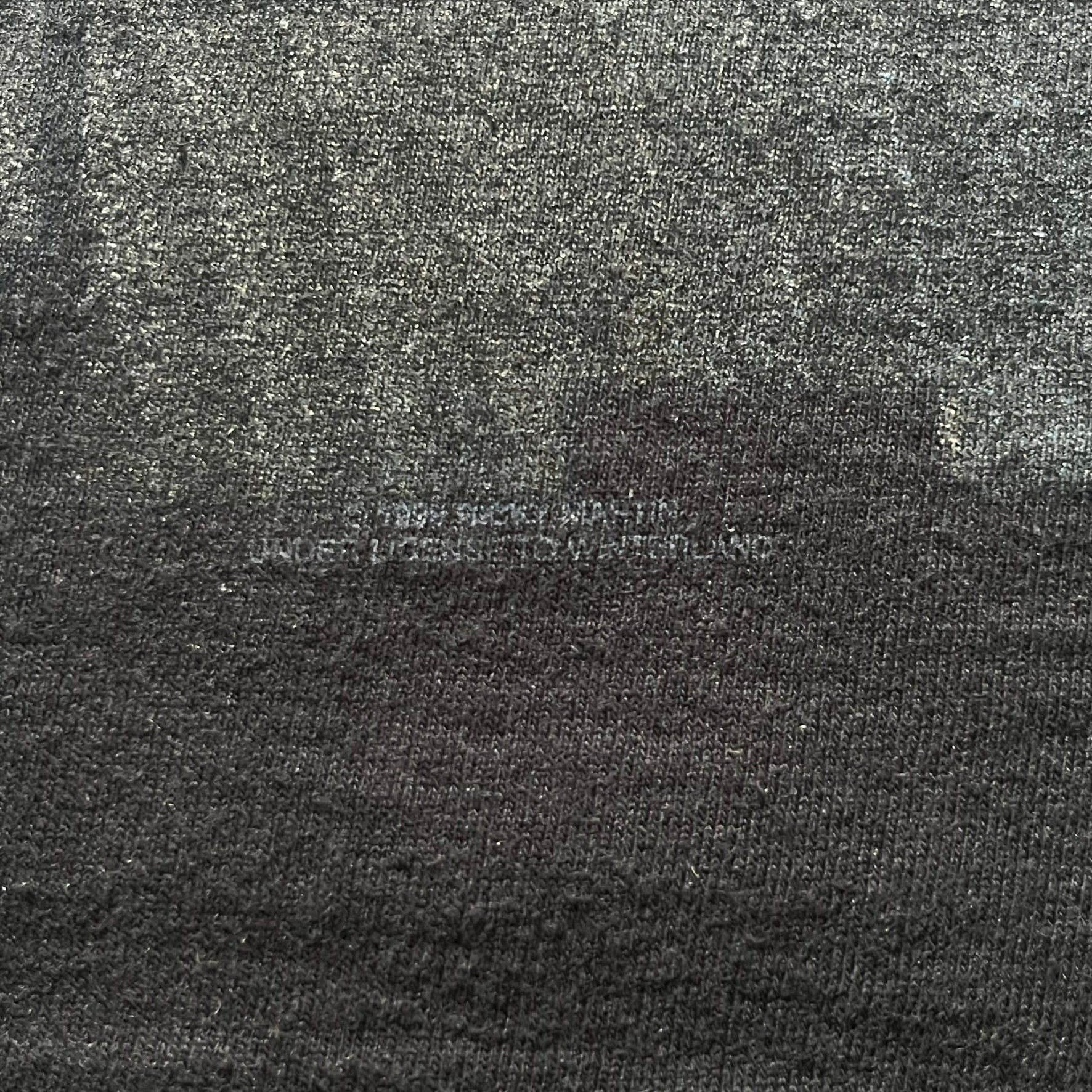 Close-up of a textured fabric with a brand logo in the center.