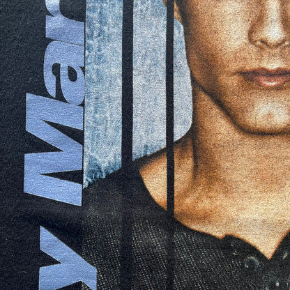 Close-up of a person wearing a black garment with branding on a blue background