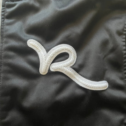 White embroidered logo on a black fabric background
