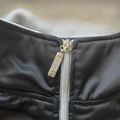 Close-up of a black jacket with a silver zipper and visible brand logo.