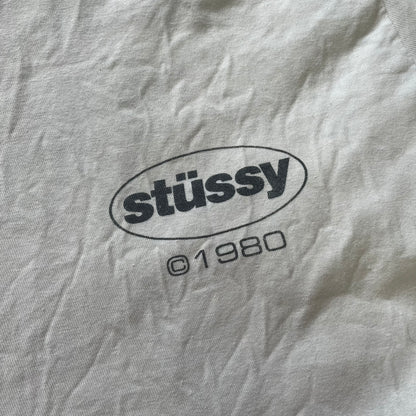 Close-up of a gray fabric with 'stussy' logo and '01980' text.