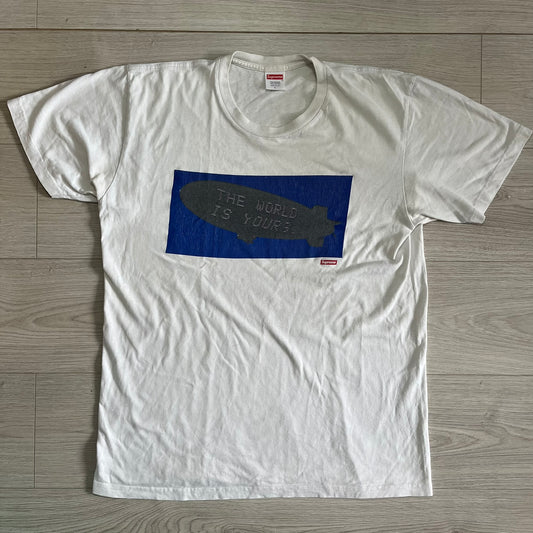 White t-shirt with a graphic design on a wooden floor