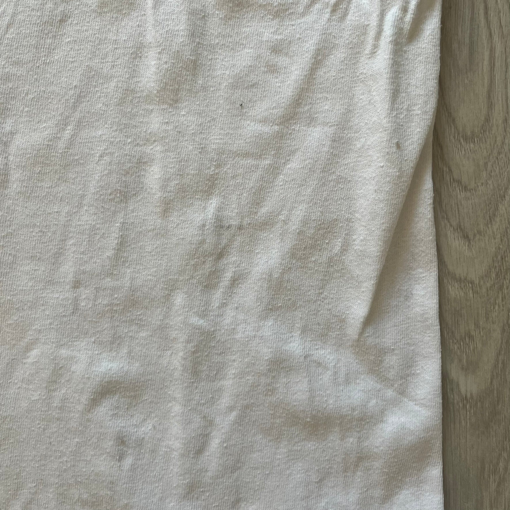 Close-up of a light gray fabric with a wooden surface background