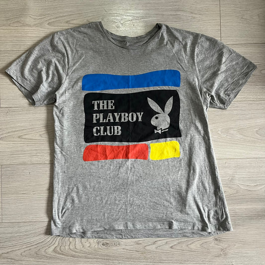 Gray t-shirt with Playboy Club logo on a wooden surface