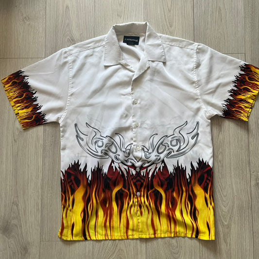 White shirt with flame and tribal design on a wooden surface
