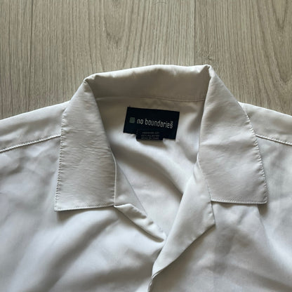 Close-up of a white shirt with a label on a wooden surface