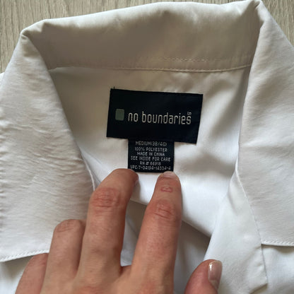 Hand holding a clothing tag on a white garment