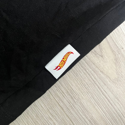 Black fabric with a Hot Wheels logo tag on a light wood floor.