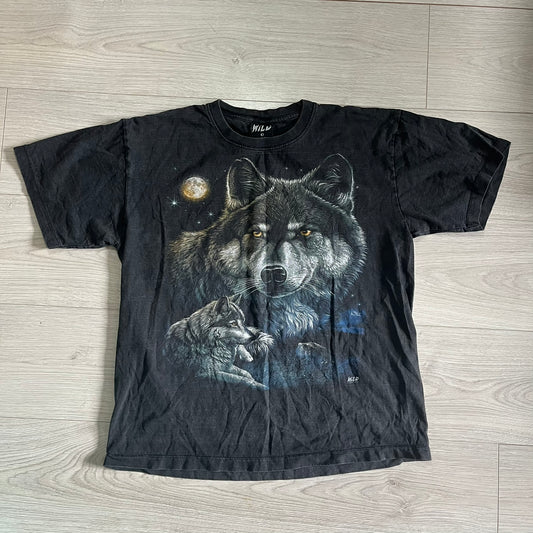 Black t-shirt with wolf graphic design on a wooden floor