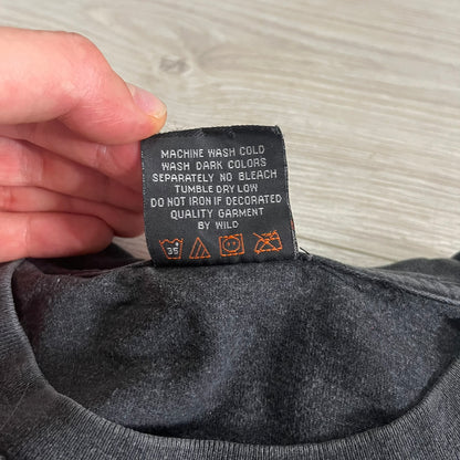 Clothing label with care instructions held by a hand against a neutral background