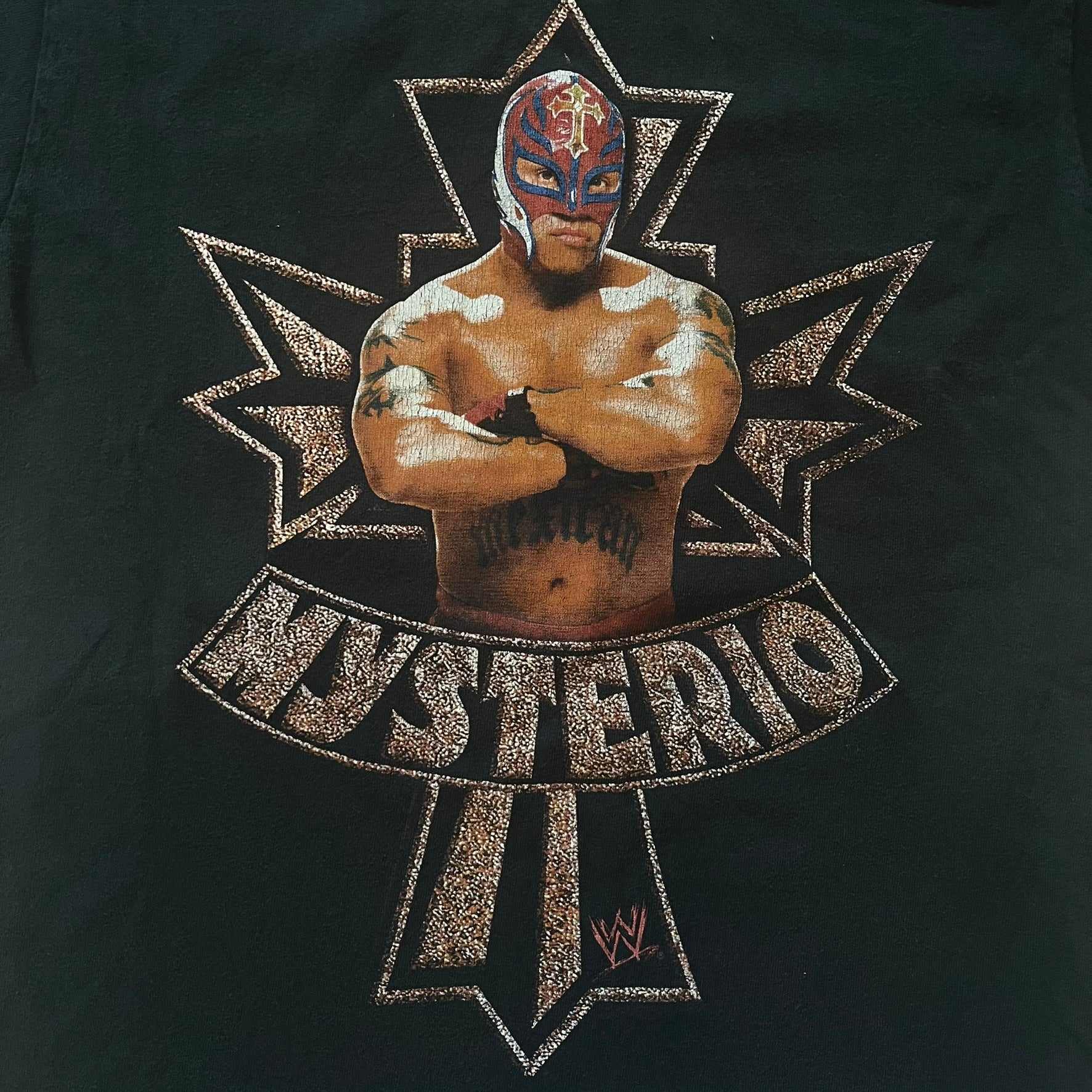 Black t-shirt with a wrestler graphic and 'Mysterio' text on a dark background